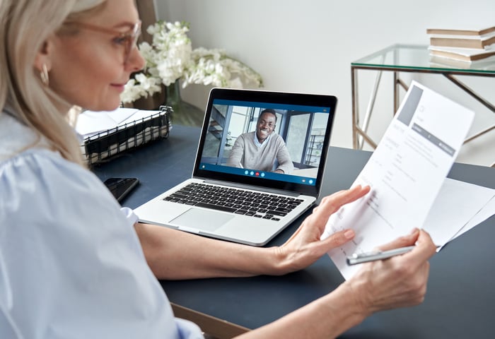a hiring manager checking the resume of a candidate during a zoom interview